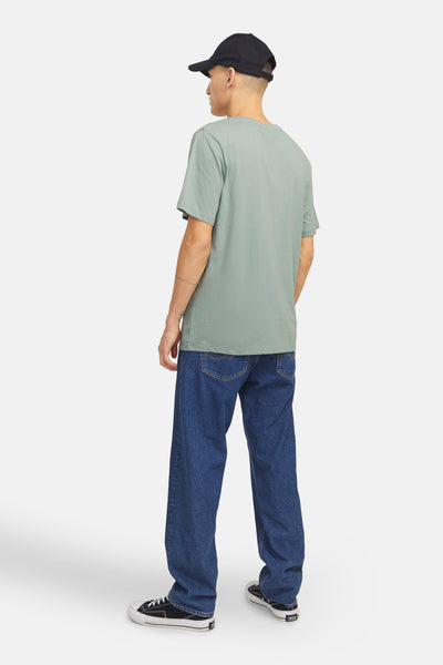 T-shirt met JACK & JONES vert, gekleed met een breed jeans en een zwarte pet.