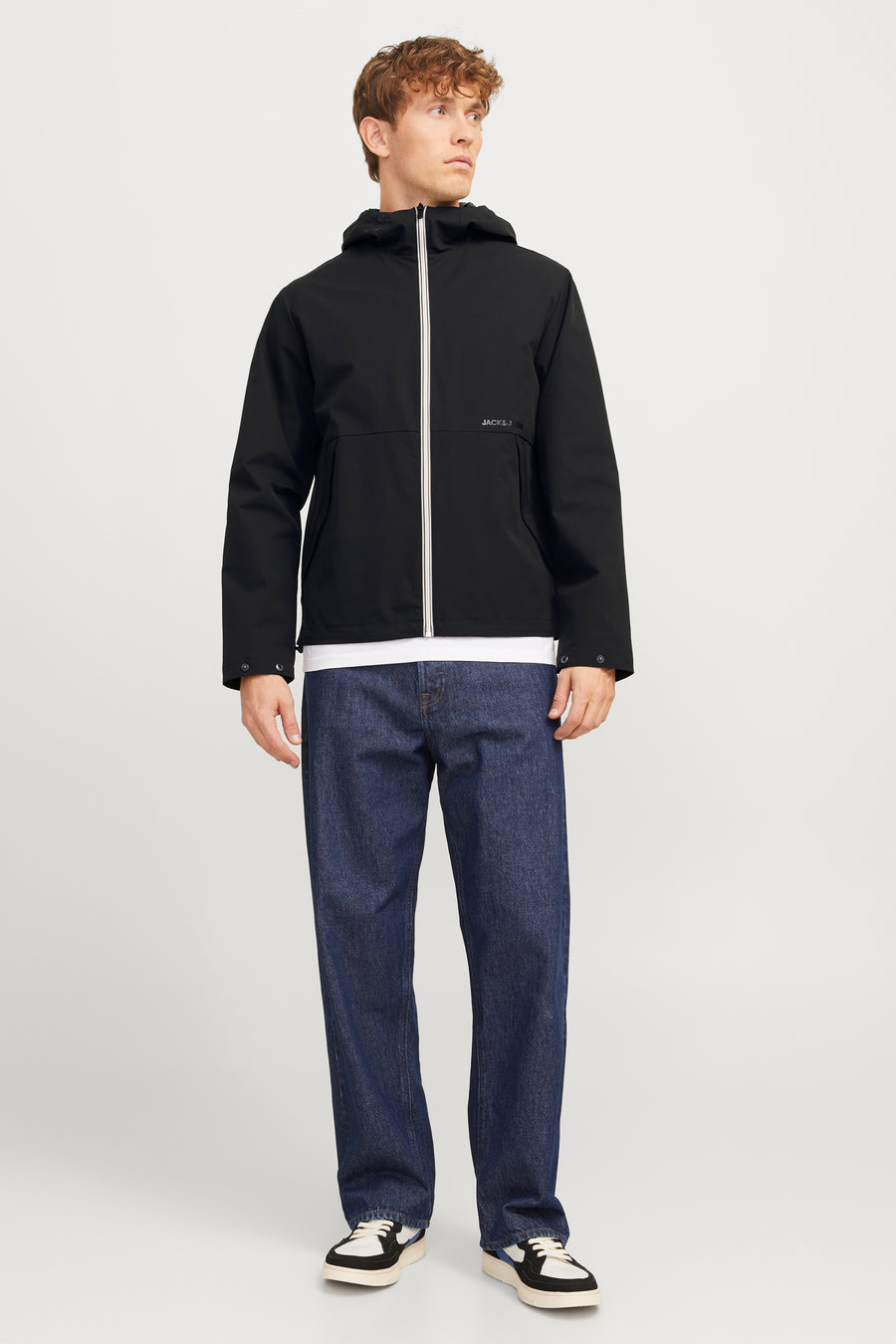 Veste courte noire de JACK & JONES, avec une fermeture éclair blanche et des boutons aux poignets.