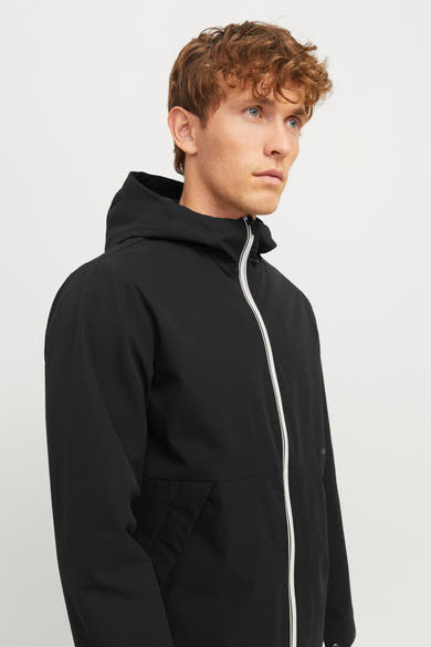 Veste courte noire de JACK & JONES avec capuche et fermeture éclair blanche contrastante.