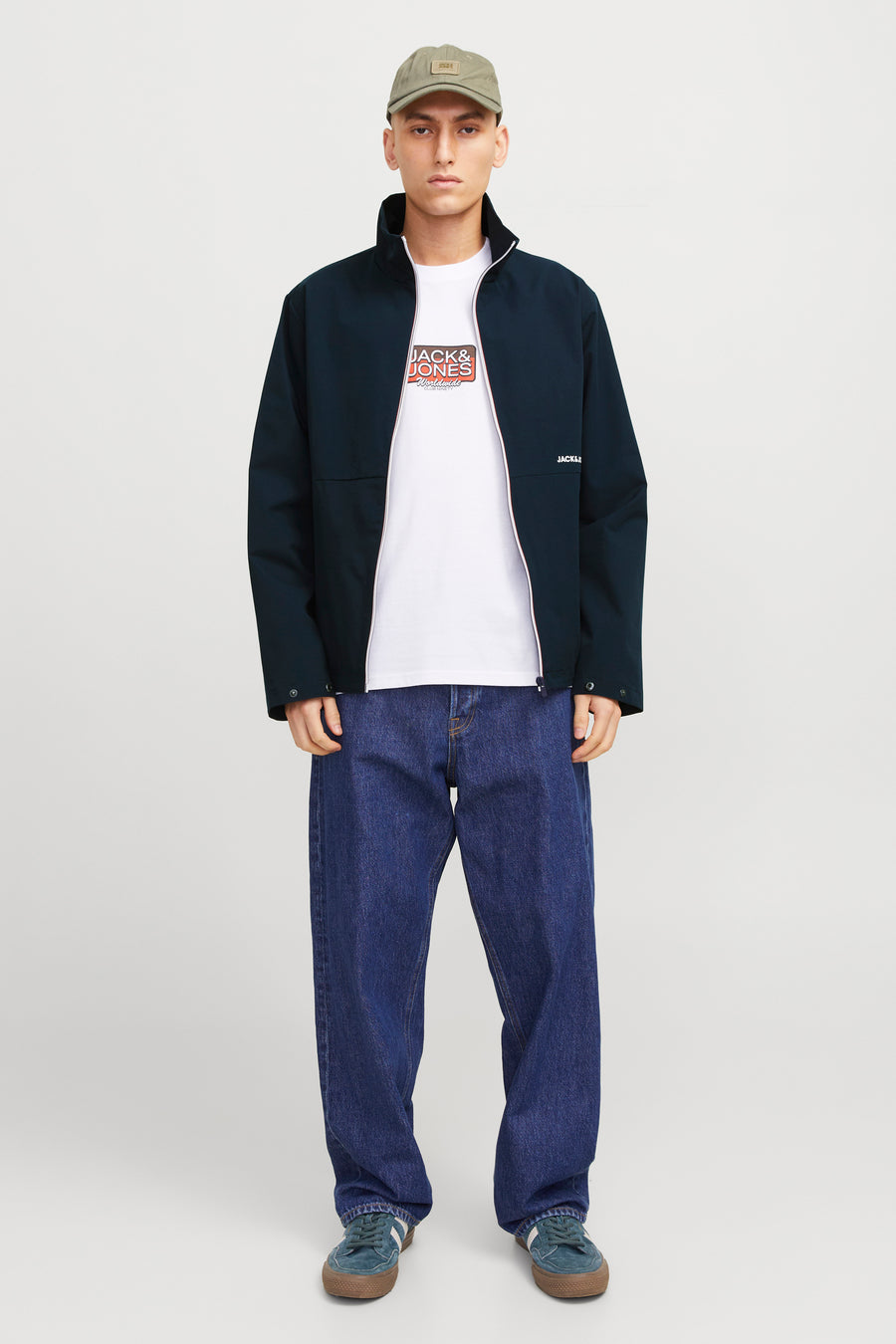 Korte blauwe jas van JACK & JONES, gedragen met een wijde jeans en suède sneakers.