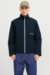 Korte blauwe jas van Jack & Jones, met witte ritssluiting en gedragen met een blauwe jeans.