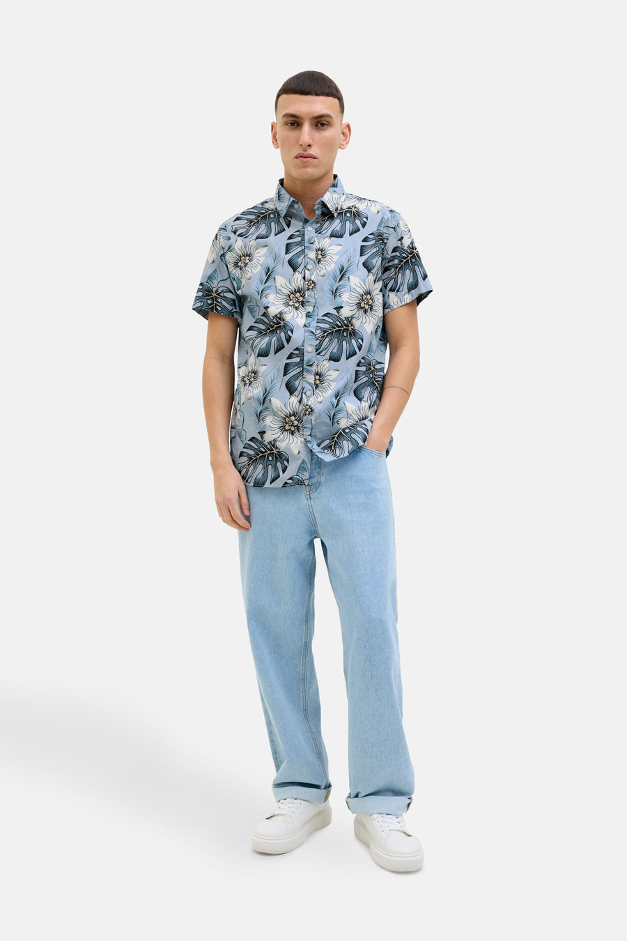 Chemise à manches courtes bleue de JACK & JONES, avec un motif floral de feuilles tropicales.
