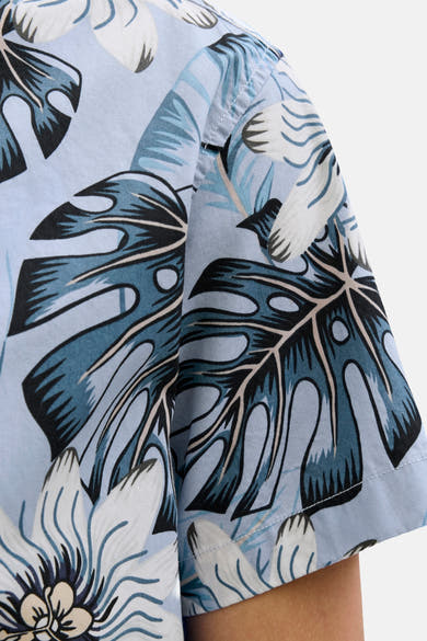 Blauwe blouse met korte mouwen van JACK & JONES met Monstera-blad- en bloemenprint, gedeeltelijke weergave.