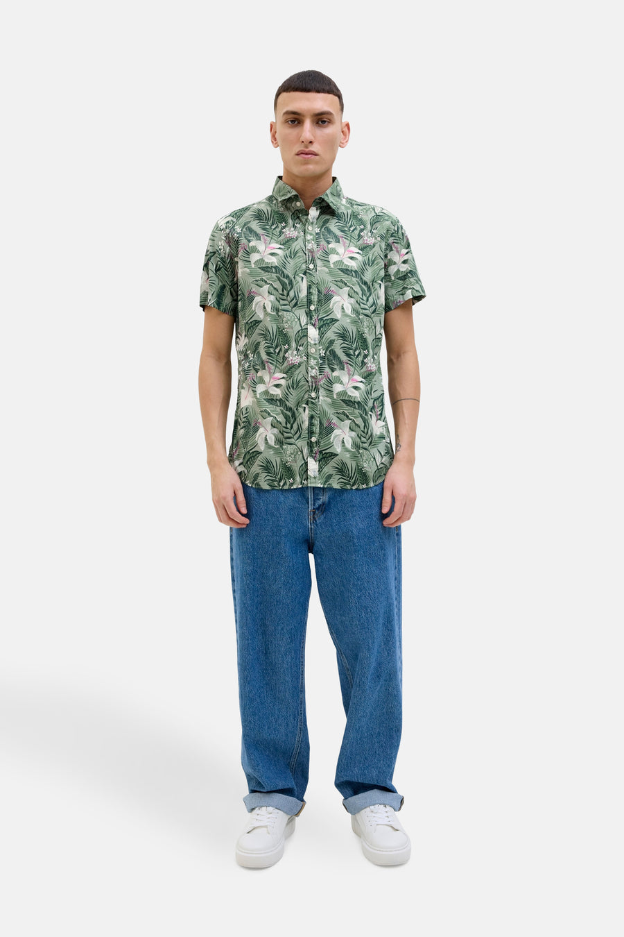 Chemise à manches courtes verte à motif floral de JACK & JONES, portée avec un jean bleu et des baskets blanches.
