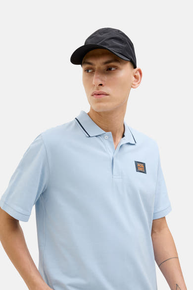 Lichtblauw poloshirt met korte mouwen van JACK & JONES, met vierkant logo op de borst en marineblauwe bies op de kraag.
