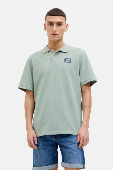 Polo kaki met Jack & JONES, met een contrasterend collard en logo op de borst, gedragen met een jeansbroek.