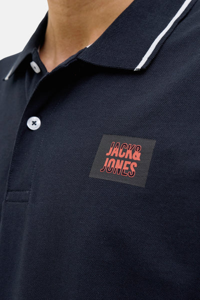 Polo bleu foncé à manches courtes de JACK & JONES, avec col contrastant blanc.