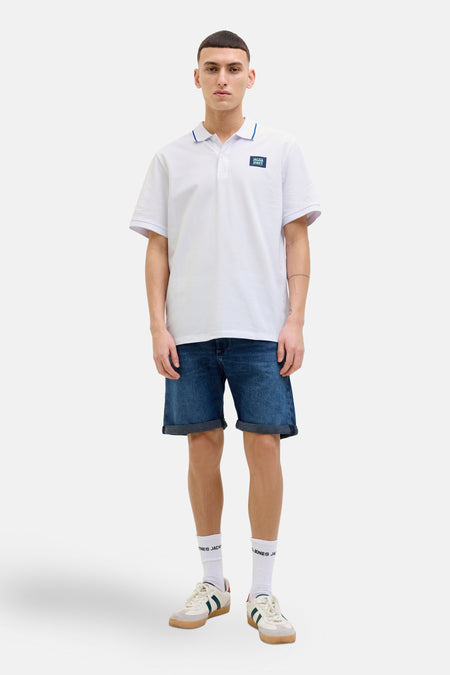 Wit poloshirt met korte mouwen van JACK & JONES, met een blauw gerande kraag gedragen met een spijkerbroekshort.