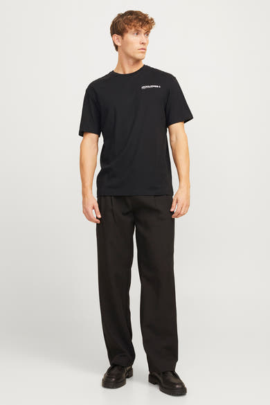 Zwart T-shirt met korte mouwen van ORIGINALS BY JACK & JONES, gedragen met een zwarte broek en bijpassende schoenen.