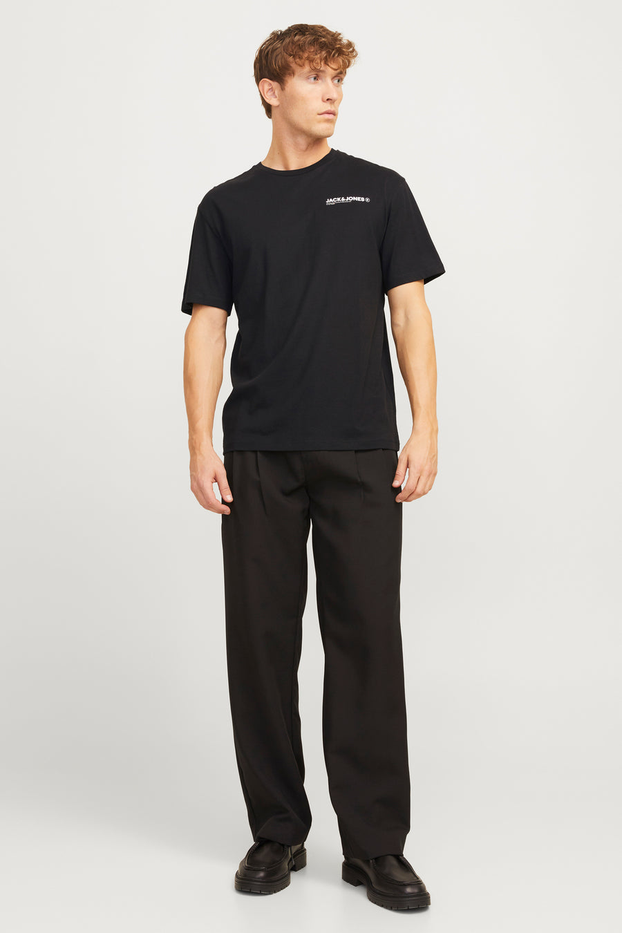 Zwart T-shirt met korte mouwen van ORIGINALS BY JACK & JONES, gedragen met een zwarte broek en bijpassende schoenen.