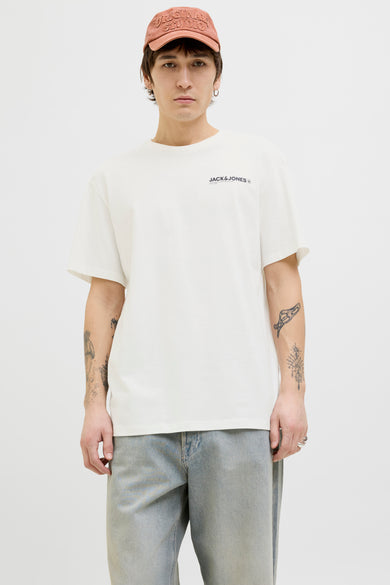 T-shirt blanc à manches courtes par Originals by Jack & Jones, porté avec une casquette et un jean décontracté.