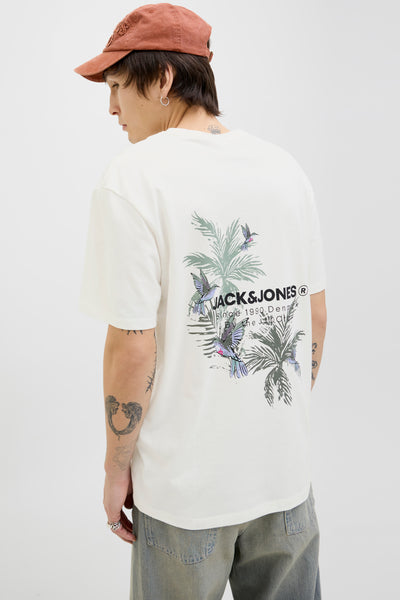 T-shirt à manches courtes blanc de ORIGINALS BY JACK & JONES, imprimé floral et oiseaux au dos, porté avec un pantalon décontracté et une casquette.