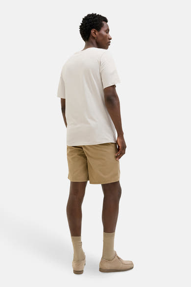 T-shirt à manches courtes écru de JACK & JONES, porté avec un short chino beige et des chaussures assorties.