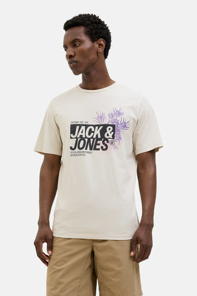 T-shirt à manches courtes écru de JACK & JONES, avec un imprimé graphique abstrait, porté avec un short beige.
