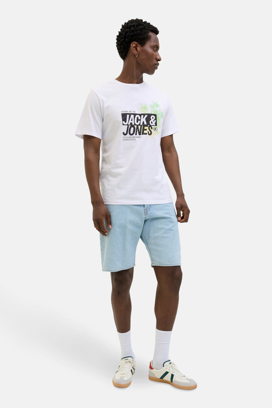 T-shirt à manches courtes blanc de JACK & JONES avec imprimé graphique, porté avec un short en jean bleu clair.