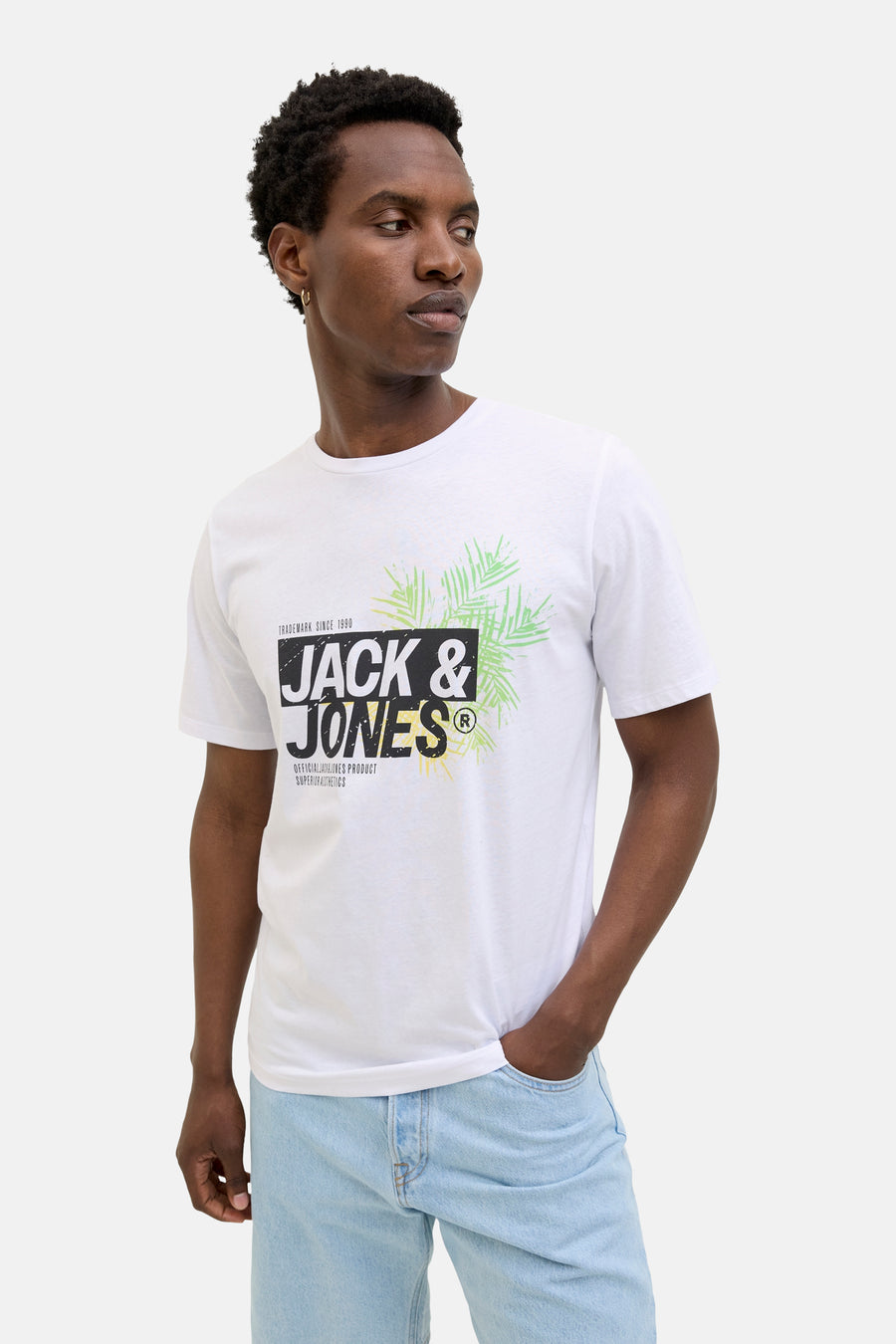 T-shirt blanc à manches courtes de JACK & JONES, avec imprimé graphique devant, porté avec un jean clair.

