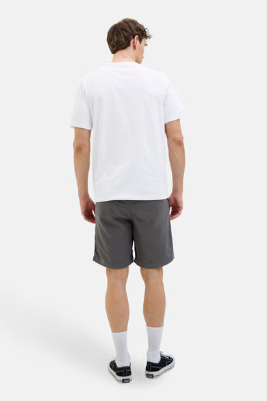 T-shirt blanc à manches courtes de ORIGINALS BY JACK & JONES, porté avec un short gris et des baskets.