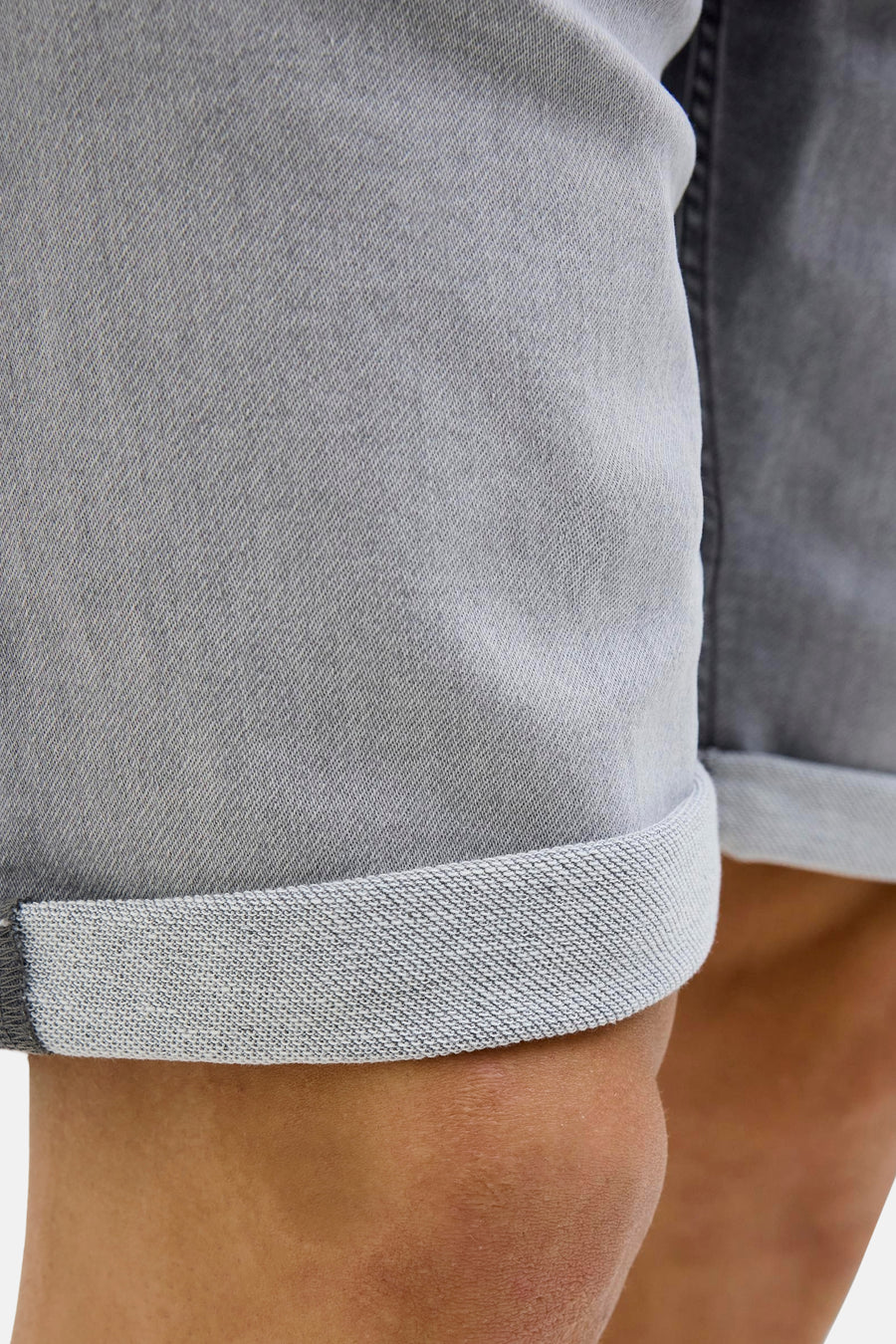 Korte spijkerbroek in grijs van JACK & JONES, met een omgeslagen zoom die de textuur van de stof laat zien.