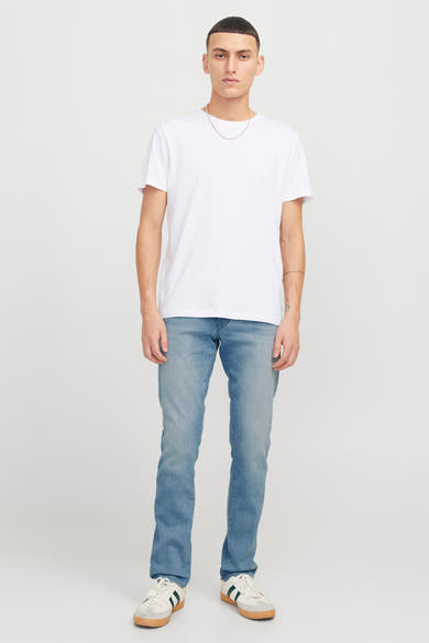 Lichtblauwe slim fit jeans van JACK & JONES JEANS INTELLIGENCE, gedragen met een wit T-shirt en sportschoenen.