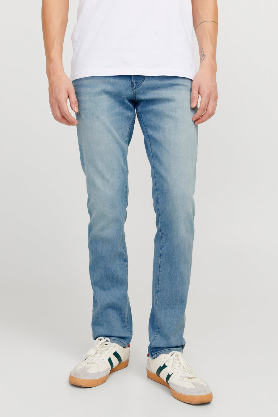 Lichtblauwe slim fit jeans van JACK & JONES JEANS INTELLIGENCE, gedragen met een wit T-shirt en witte sneakers.