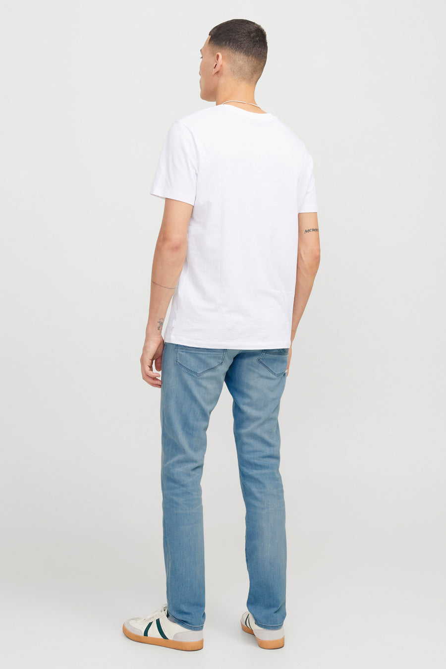 Lichtblauwe slim fit jeans van JACK & JONES JEANS INTELLIGENCE, gedragen met een wit T-shirt en sneakers.