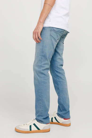 Slim jeans in lichtblauw denim van JACK & JONES JEANS INTELLIGENCE, gedragen met een wit T-shirt en sneakers.