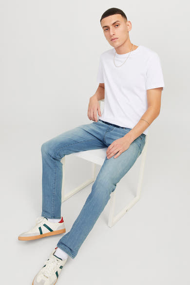 Slim jeans in lichtblauw denim van JACK & JONES JEANS INTELLIGENCE, gedragen met een wit T-shirt en witte sneakers.