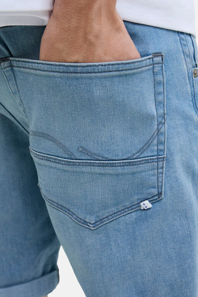 Short en denim bleu clair de JACK & JONES, poche arrière avec couture décorative, porté avec un t-shirt blanc.
