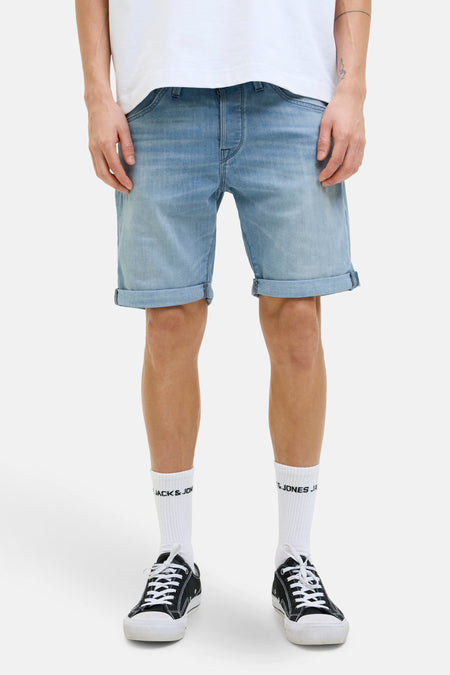 Korte spijkerbroek in lichtblauw van JACK & JONES, met omgeslagen zomen, gedragen met witte sokken en zwarte sneakers.