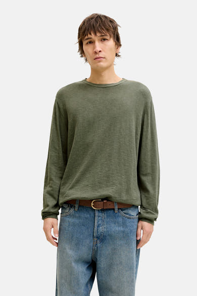 Pull à col rond vert de PREMIUM by JACK & JONES, porté avec une ceinture marron et un jean bleu.
