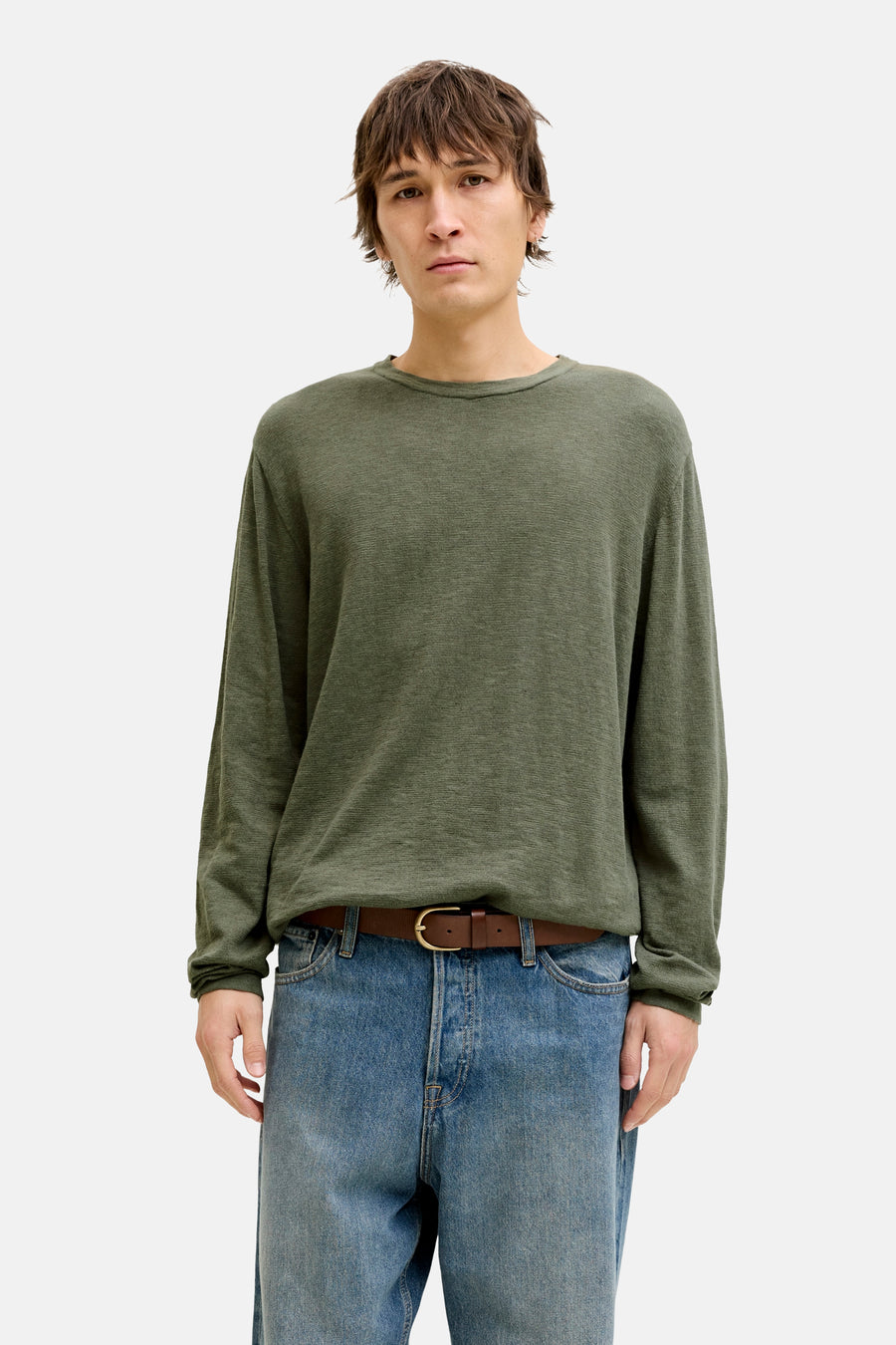 Pull à col rond vert de PREMIUM by JACK & JONES, porté avec une ceinture marron et un jean bleu.
