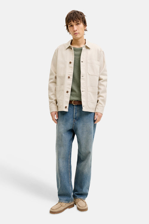 Pull à col rond vert de PREMIUM by JACK & JONES, porté avec une veste beige et un jean bleu.