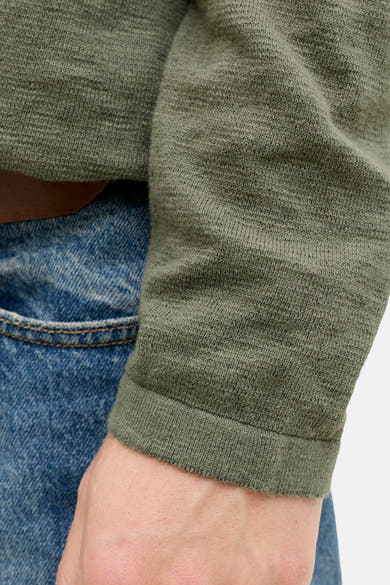 Pull à col rond vert de PREMIUM by JACK & JONES, en maille texturée, porté avec un jean bleu.