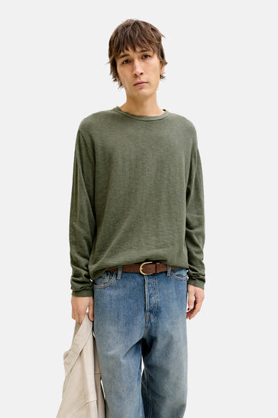Pull à col rond vert par PREMIUM by JACK & JONES, porté avec un jean bleu et une ceinture marron.