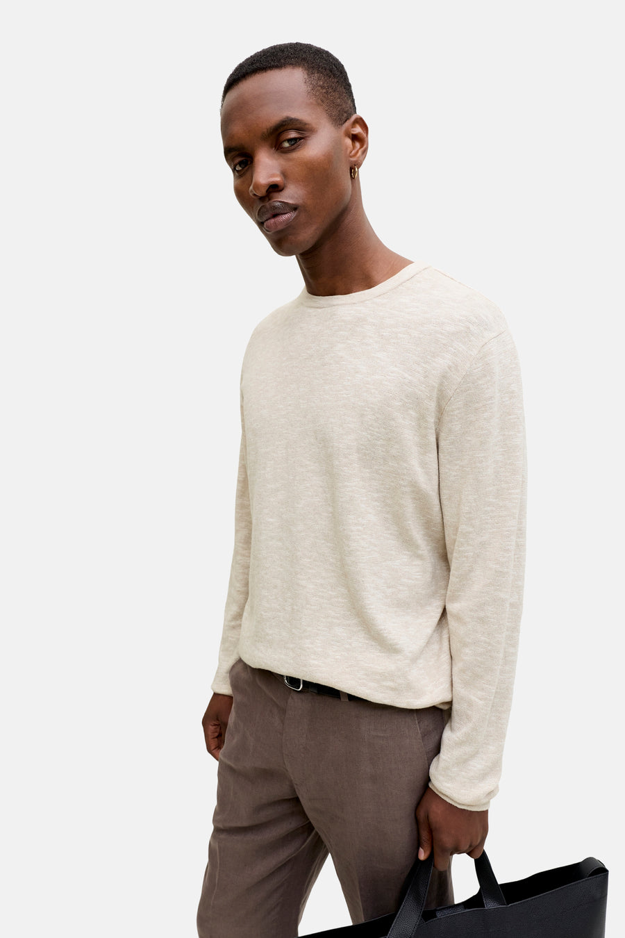 Pull à col rond beige de PREMIUM by JACK & JONES, porté avec un pantalon marron et boucle d'oreille dorée.