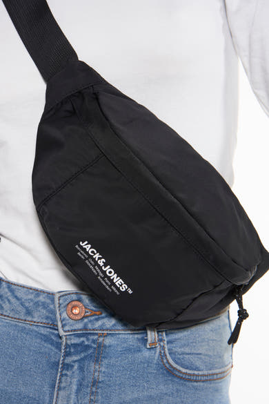 Zwarte heuptas van ACCESSORIES BY JACK & JONES, gedragen over een lichtblauwe jeans, met zwart trekkoord.