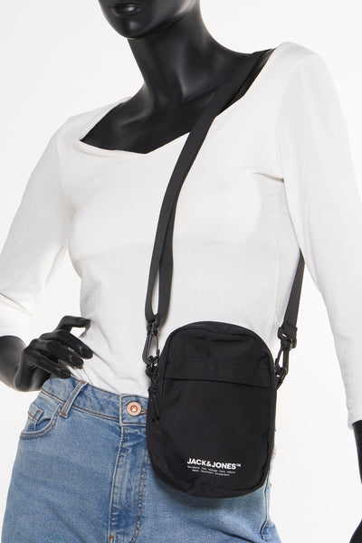 Sac bandoulière noir de ACCESSORIES BY JACK & JONES, porté croisé sur un mannequin vêtu d'un t-shirt blanc et d'un jean.