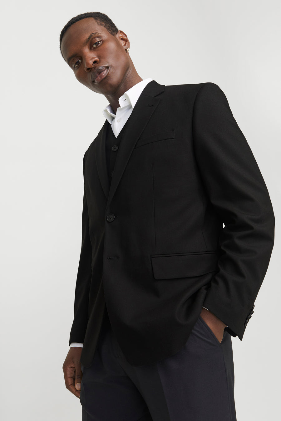 Blazer noir de PREMIUM by JACK & JONES, porté sur un gilet et une chemise blanche.