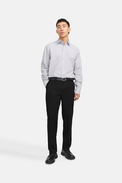 Pantalon de costume noir de PREMIUM by JACK & JONES porté avec une ceinture noire et une chemise rayée.