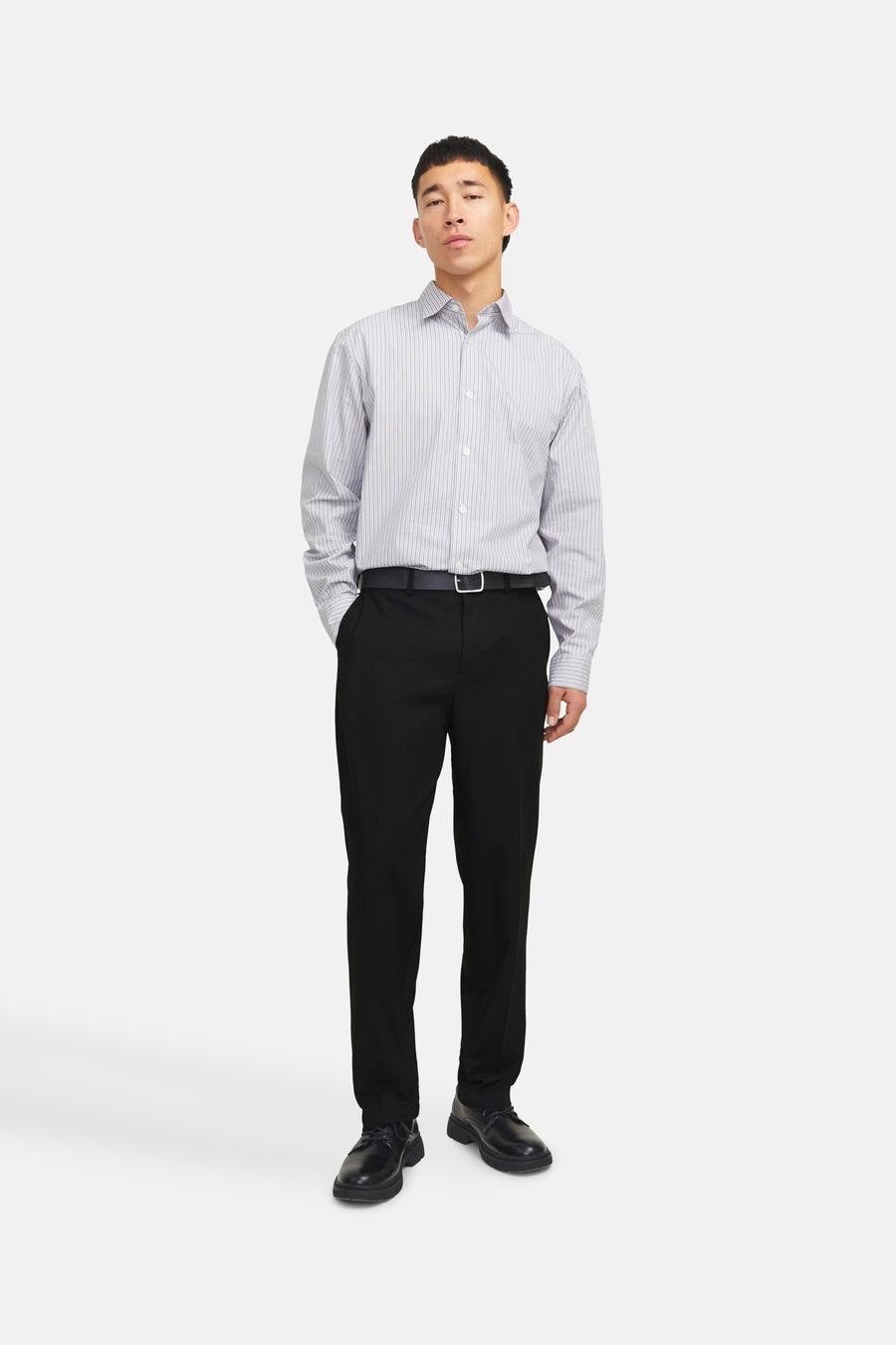 Pantalon de costume noir de PREMIUM by JACK & JONES porté avec une ceinture noire et une chemise rayée.