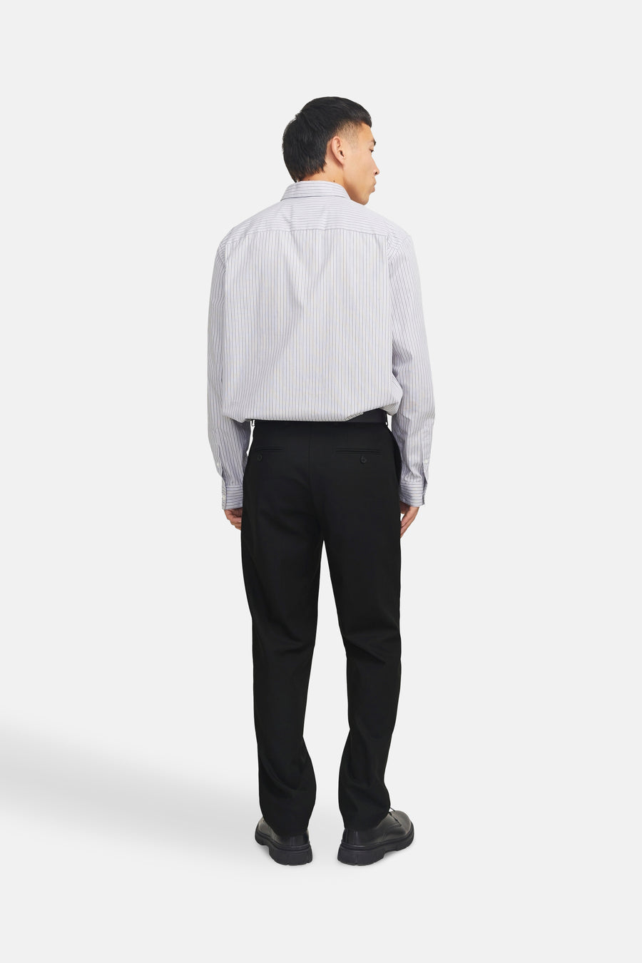 Pantalon de costume noir de PREMIUM by JACK & JONES, coupe droite, porté avec une chemise rayée.