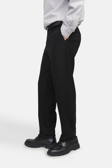 Pantalon de costume noir de PREMIUM by JACK & JONES, porté avec une chemise rayée et des chaussures noires.