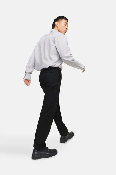 Pantalon de costume noir de PREMIUM by JACK & JONES, porté avec une chemise rayée et des chaussures habillées noires.
