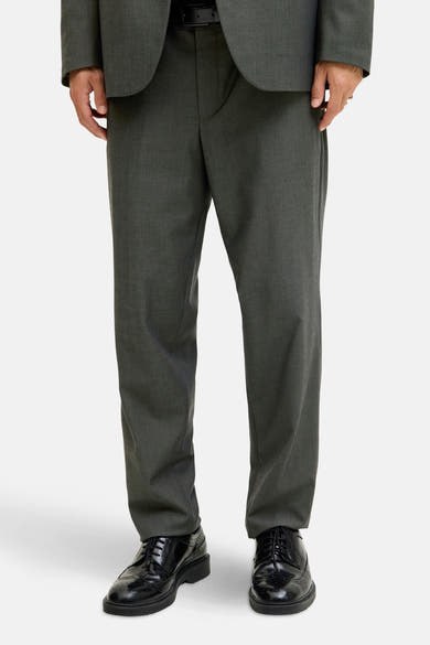 Groene kostuumbroek van PREMIUM by JACK & JONES, gedragen met een bijpassend jasje en zwarte schoenen.