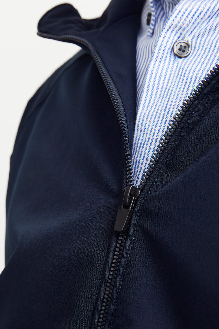 Donkerblauwe regenjas van JACK & JONES met zichtbare ritssluiting en gestreepte voering.
