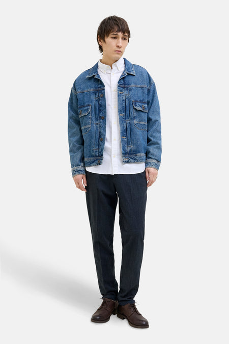 Blauwe chino JACK & JONES JEANS INTELLIGENCE met een wit overhemd en een spijkerjasje.