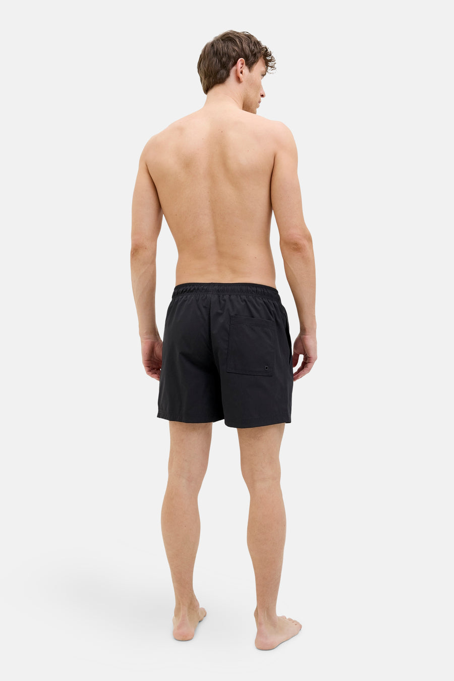 Short de bain noir de JACK & JONES JEANS INTELLIGENCE, vu de dos sur un homme torse nu.