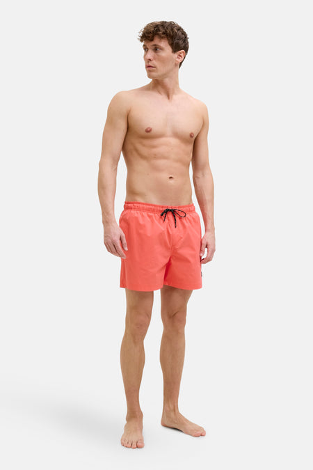 Short de bain rose par JACK & JONES JEANS INTELLIGENCE, porté par un homme torse nu.