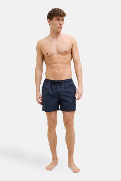 Short de bain bleu par JACK & JONES JEANS INTELLIGENCE, porté par un homme torse nu.