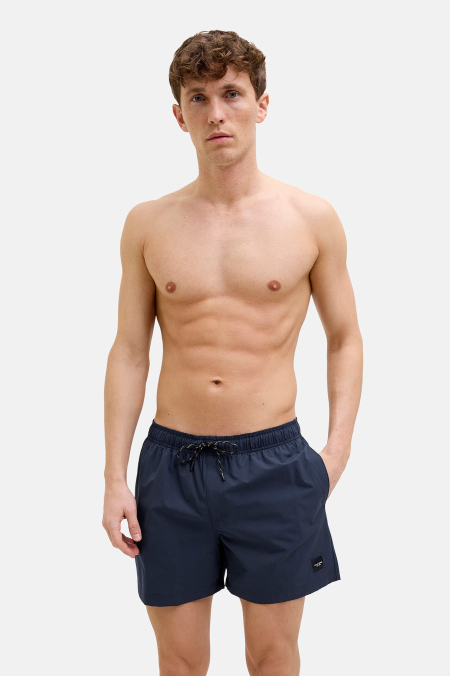 Short de bain bleu par JACK & JONES JEANS INTELLIGENCE, porté par un homme torse nu.

